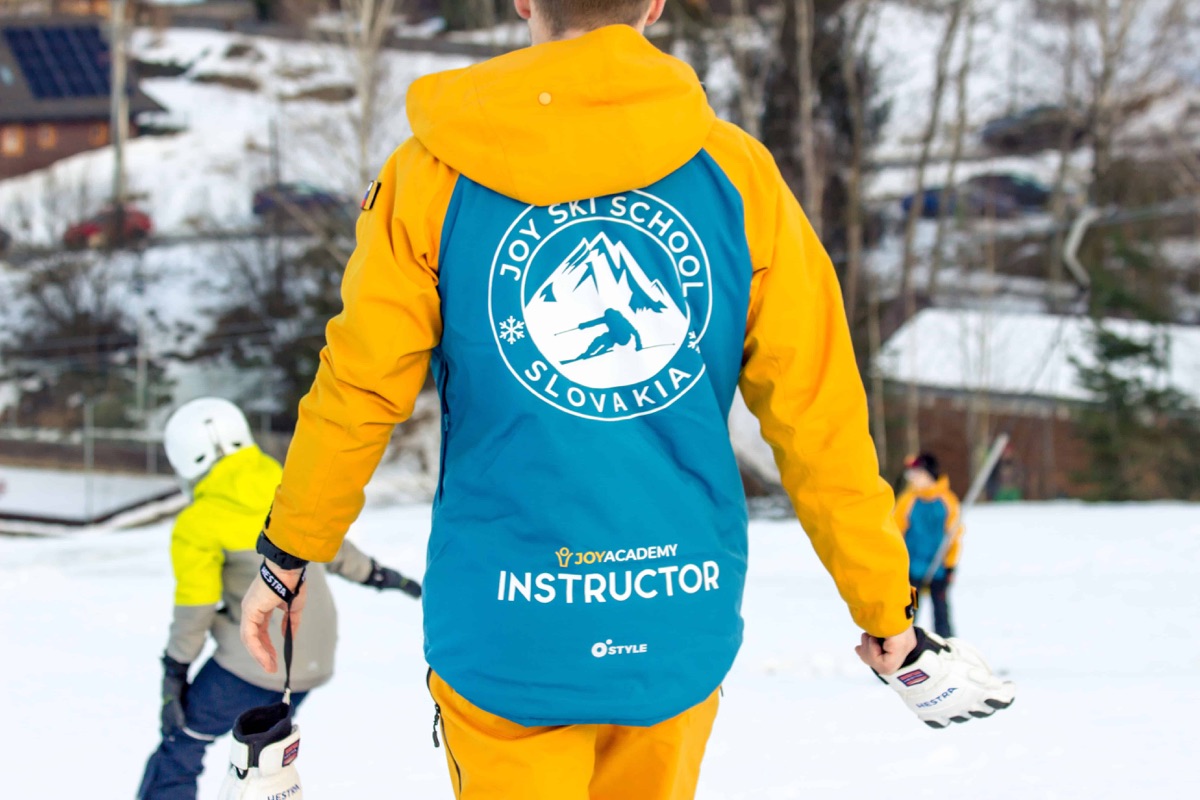 Inštruktor Joy Academy zozadu so značkovou bundou