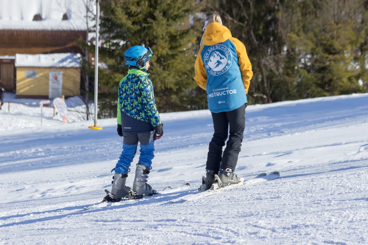 Joy Academy instructor with a child on the slope