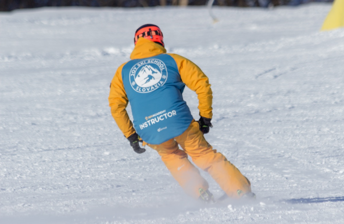 Joy Academy instructor skiing, seen from behind