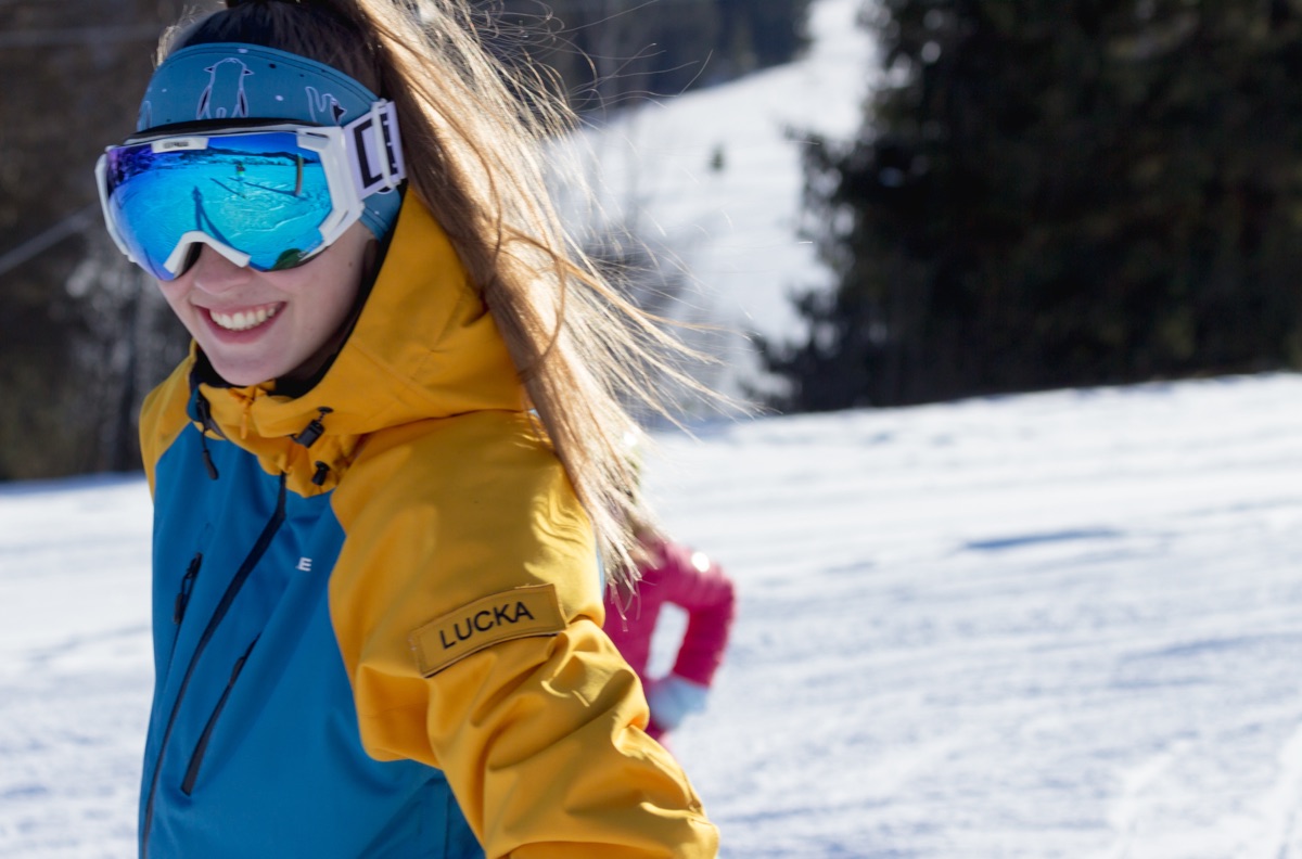 Smiling instructor in goggles on the slope