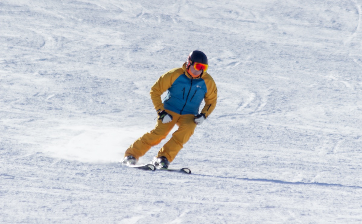Instructor carving a turn on a groomed slope