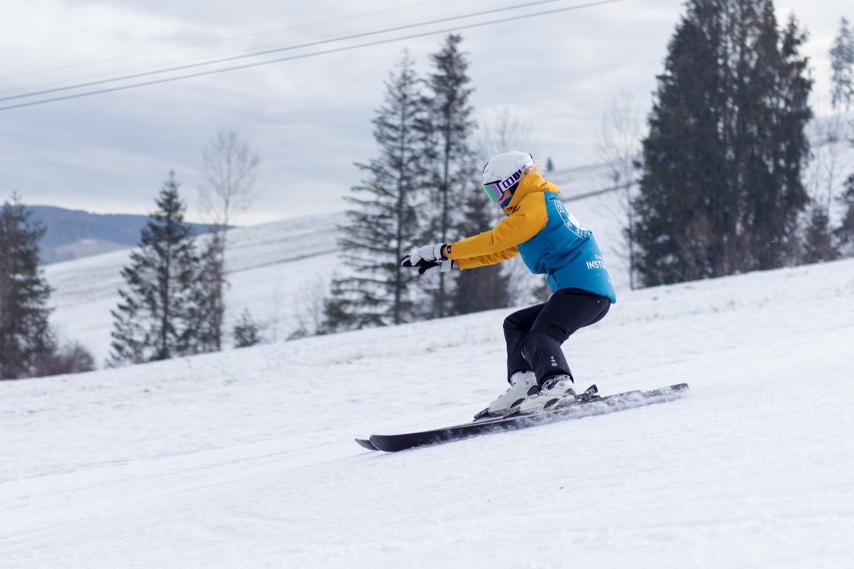 Instructor skiing among spruce trees