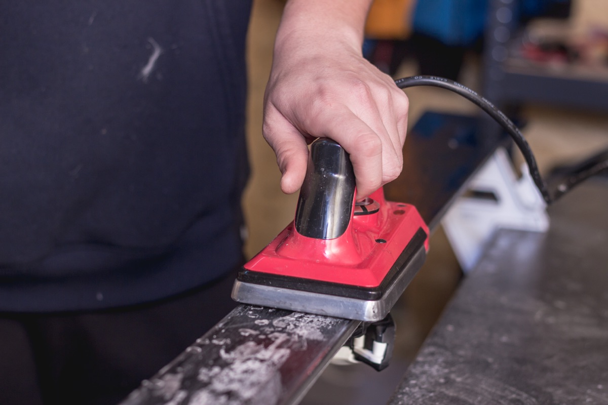 Waxing a ski in the ski service workshop